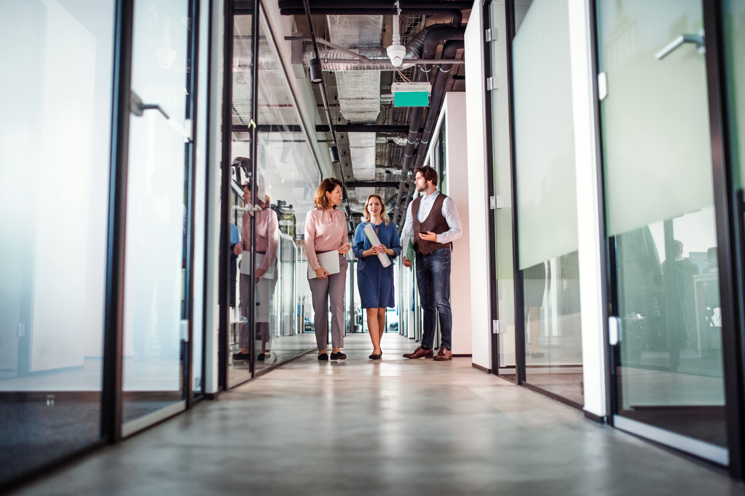 Group of business people walking in an office building, talking.